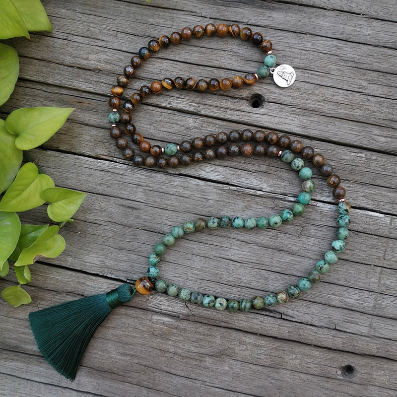 Collar de ojo de tigre y turquesa africana con borla verde sobre madera