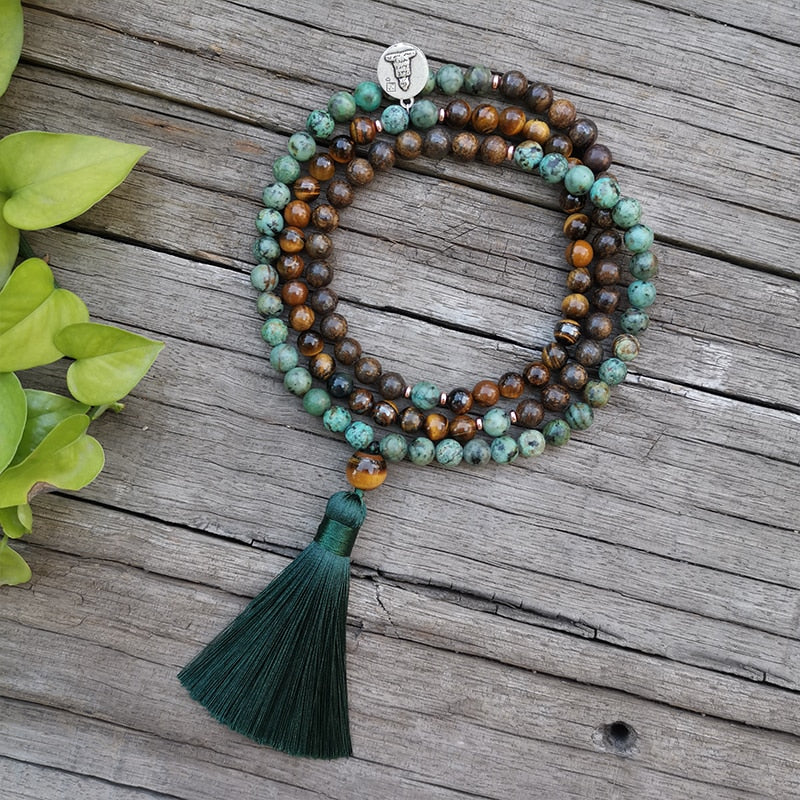 Collar de ojo de tigre y turquesa africana con borla verde sobre madera